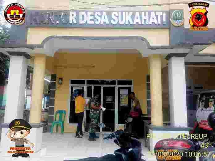 Bhabinkamtibmas Desa Sukahati AIPTU DWIYONO CIKIYADI memasang maklumat Kapolri dikantor Desa Sukahati