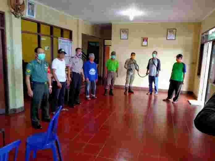 Bhabinkamtibmas melakukan penyemprotan cairan disinfektan