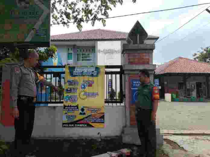 Bhabinkamtibmas Desa Bojong Rangkas dan Babinsa Pasang Pamflet pencegahan Virus Corona.